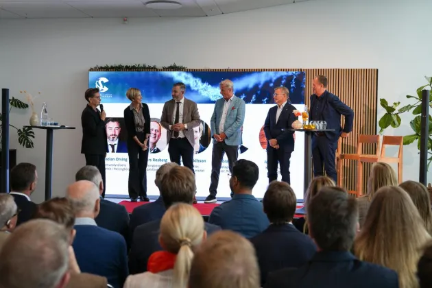 Personer på en scen och personer i publik. foto.