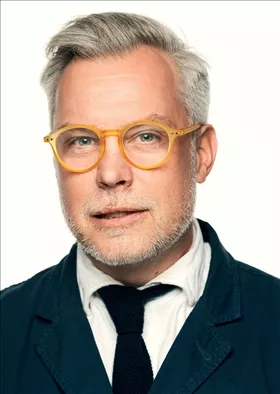 Porträttbild av man med glasögon och slips. Foto